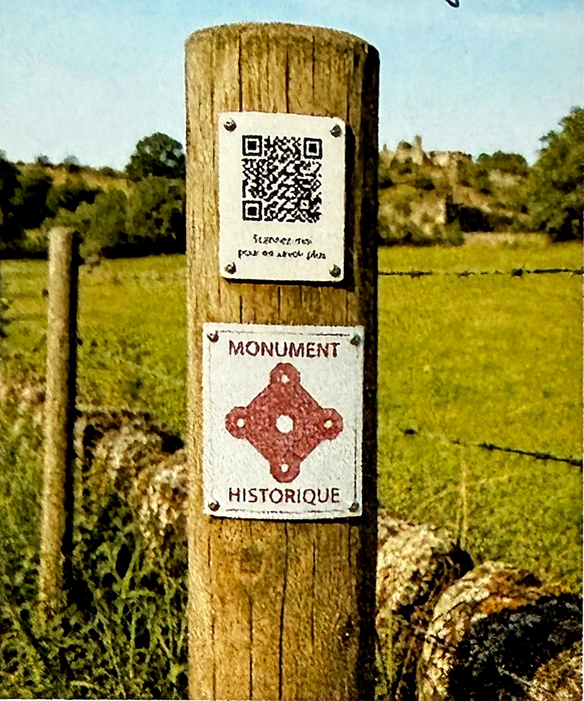 Poteau d'information en bois portant un QR code et une plaque « Monument historique »